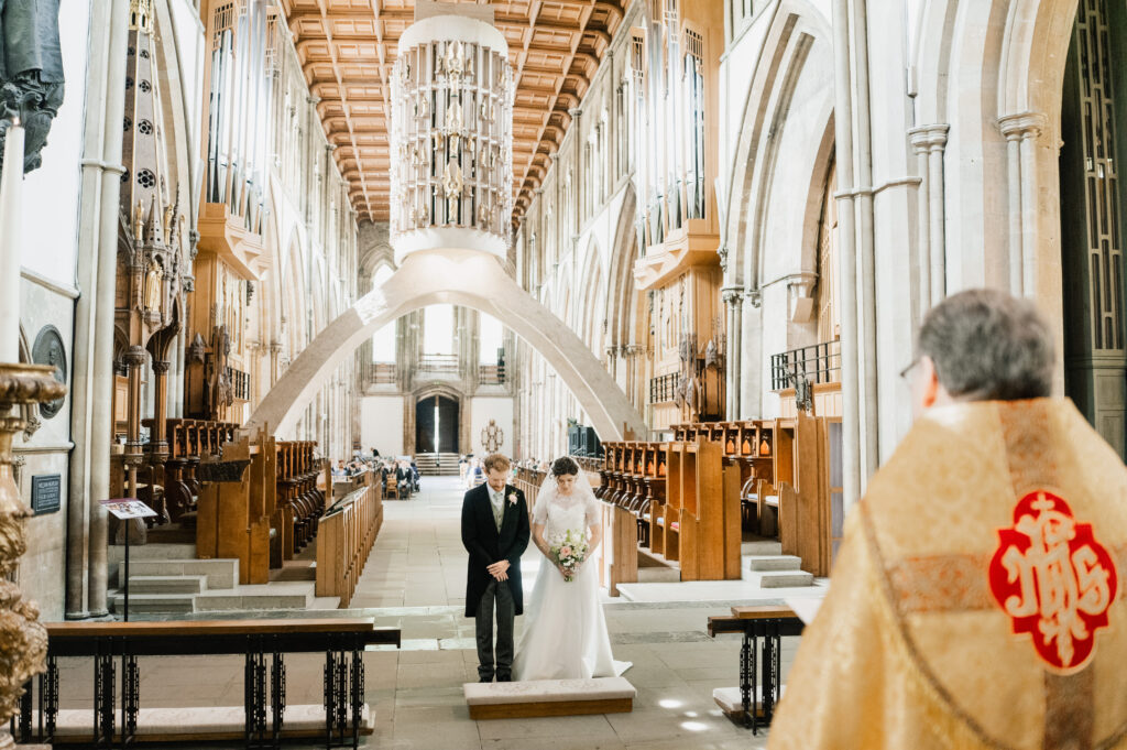 wedding-couple-bowing-their-heads-in-prayer-at-a-church-wedding